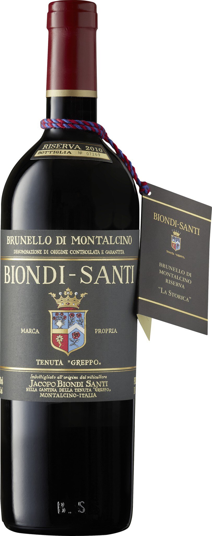 Eine Flasche Rotwein mit einer dunklen, eleganten Etikettierung. Darauf steht -Brunello di Montalcino Riserva 2010- und der Brandname -Biondi-Santi-. Die Flasche trägt eine nummerierte Plakette und ist mit einem doppelten Band dekoriert.