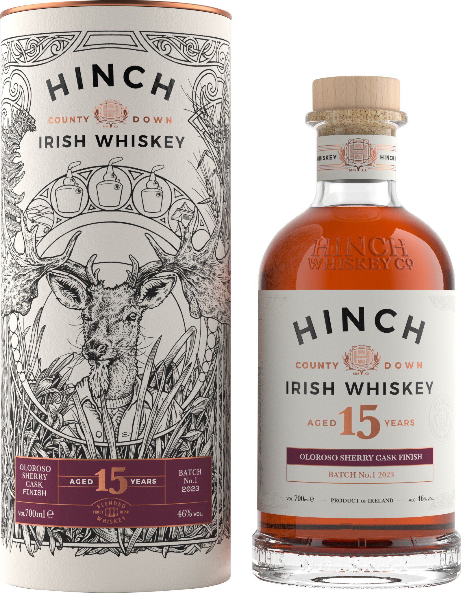 Eine Flasche Hinch 15 Jahre alter Whiskey steht auf einem Tisch, umgeben von einer dekorativen Verpackung mit einem stilisierten Tiermotiv. Die Flasche hat einen runden, klaren Korpus und einen weißen Etikett.