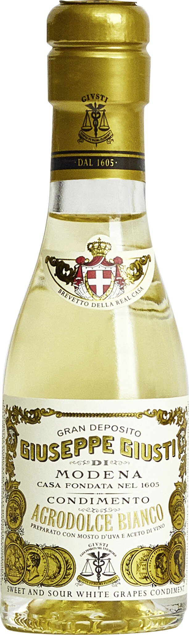 Eine kleine Flasche mit goldener Kappe und weißem Etikett. Das Etikett zeigt den Namen des Produkts und ist mit dekorativen Elementen verziert. Die Flasche könnte einen alkoholischen Inhalt haben.