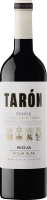 Eine Flasche Rotwein steht im Mittelpunkt, die ein elegantes, schwarzes Design mit einem klaren Etikett zeigt. Der Name -TARÓN- ist in großen Buchstaben abgedruckt, umgeben von Informationen über den Wein.