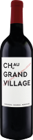 Eine Weinflasche mit rotem Etikett, auf dem -Château Grand Village- in schwarzer Schrift steht. Die Flasche hat einen dunkelroten Deckel und einen schlanken Körper.