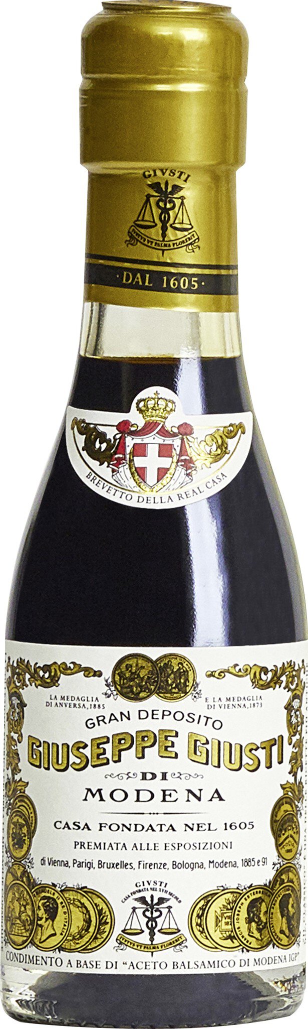 Eine schmale Glasflasche mit einem goldenen Schraubverschluss. Der Inhalt ist eine dunkle Flüssigkeit, vermutlich ein Balsamico-Essig, mit einer Etikettierung, die herkunfts- und markenspezifische Infos enthält.