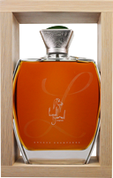 Ein orangefarbener Parfümflakon mit einer geschwungenen Form steht in einer Holzbox. Der Flakon hat einen silbernen Verschluss und eine elegante Gravur.