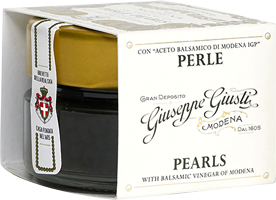 Schwarzes Glasbehälter mit goldfarbenem Deckel, beschriftet mit dem Namen -Georges Genset- und dem Wort -Perle-. Darin befinden sich Perlchen, vermutlich Lebensmittel, in einem eleganten Verpackungsdesign.